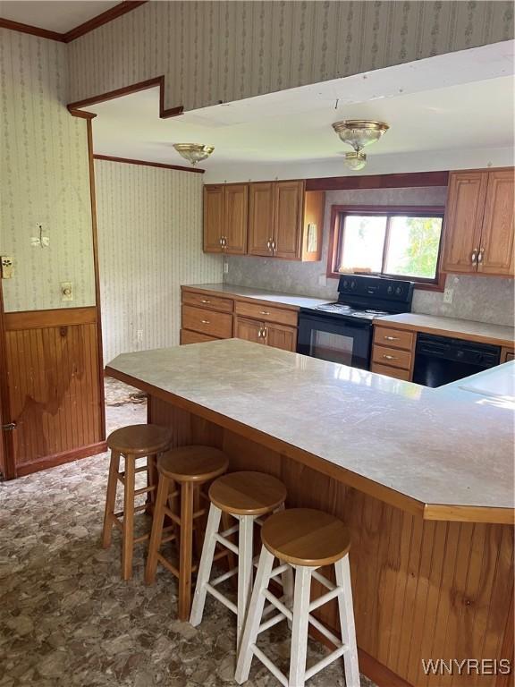 4535 Holley Byron Rd, Clarendon, NY 14470 - kitchen featuring black appliances, wallpapered walls, light countertops, a breakfast bar, and crown molding