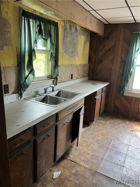 4535 Holley Byron Rd, Clarendon, NY 14470 - kitchen featuring light countertops, wood walls, and dark brown cabinets