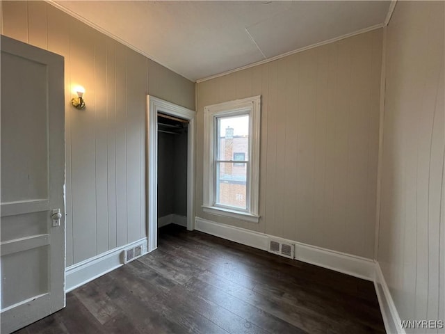 288 Abbott Rd, Buffalo, NY 14220 - unfurnished bedroom with ornamental molding, dark wood-style flooring, and wood walls