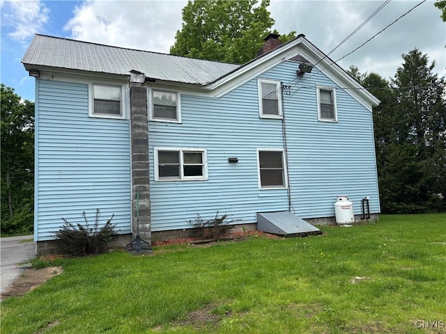 1046 Ammon Rd, Lewis, NY 13489 - back of property with a lawn, a metal roof, and a chimney