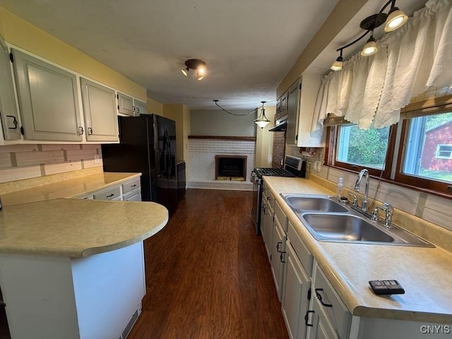 1046 Ammon Rd, Lewis, NY 13489 - kitchen with stainless steel range with gas cooktop, a fireplace, light countertops, and dark wood-style floors