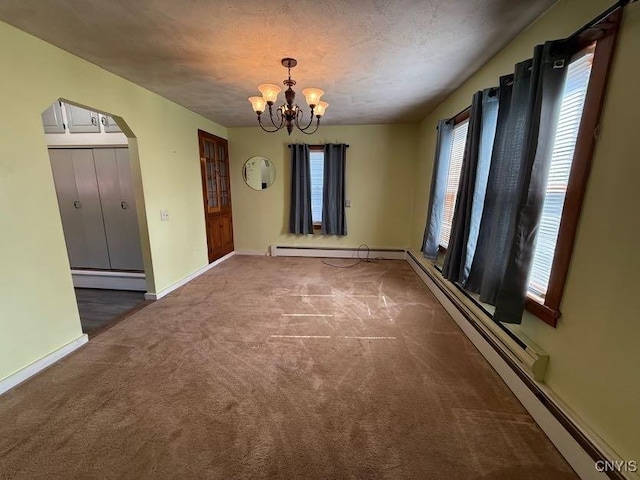 1046 Ammon Rd, Lewis, NY 13489 - carpeted empty room featuring arched walkways, a baseboard heating unit, and a chandelier