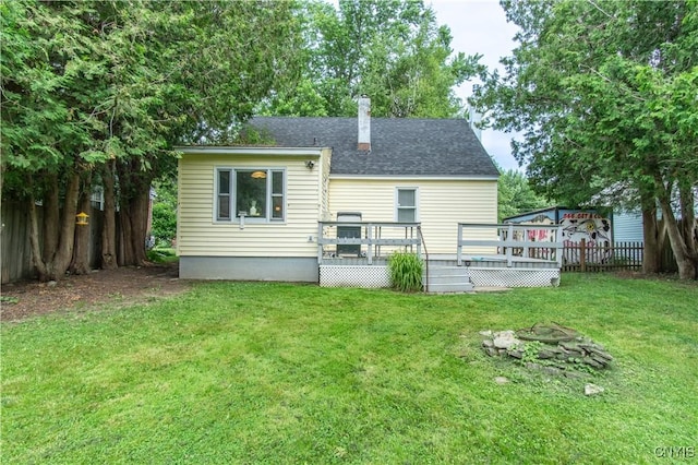 311 Iroquois Ave W, Watertown City, NY 13601 - back of property featuring a fire pit, a wooden deck, a fenced backyard, and a chimney