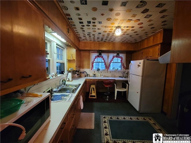 421 Falconer St, Jamestown, NY 14701 - kitchen featuring freestanding refrigerator, light countertops, and brown cabinets