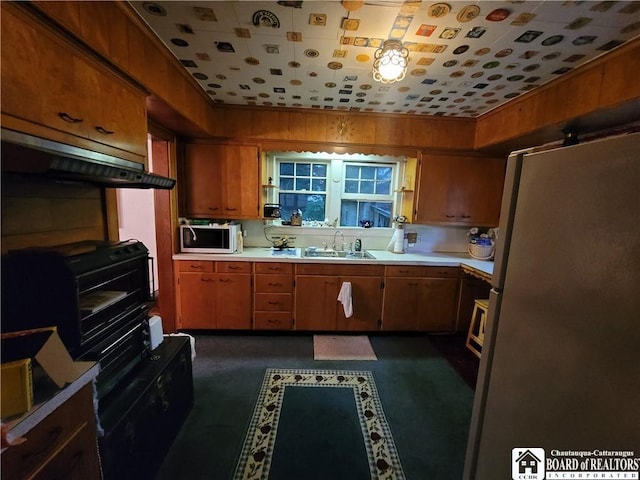 421 Falconer St, Jamestown, NY 14701 - kitchen featuring freestanding refrigerator, white microwave, extractor fan, light countertops, and brown cabinetry