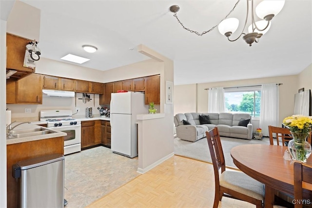 103 Walrath Dr, Sullivan, NY 13037 - kitchen with white appliances, brown cabinetry, light countertops, a chandelier, and open floor plan