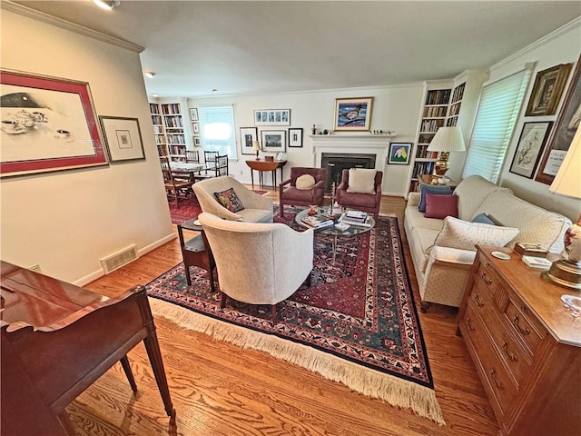 10 Danbury Cir N, Brighton, NY 14618 - living area featuring wood finished floors, crown molding, built in shelves, and a fireplace