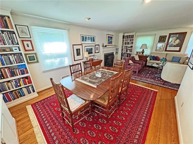 10 Danbury Cir N, Brighton, NY 14618 - dining room with a fireplace, ornamental molding, built in features, and wood finished floors