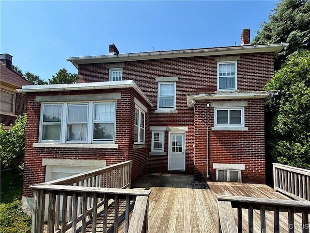 633 Pleasant St, Utica, NY 13501 - view of front of property featuring a chimney, brick siding, and a deck