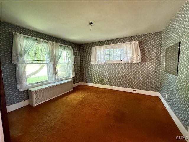 633 Pleasant St, Utica, NY 13501 - carpeted empty room featuring radiator and wallpapered walls