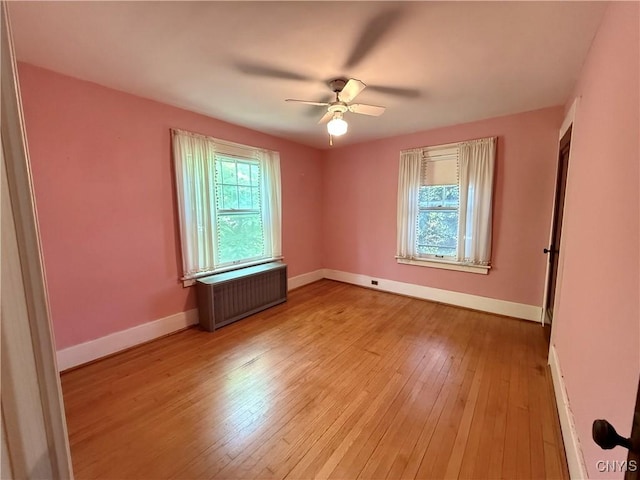 633 Pleasant St, Utica, NY 13501 - spare room with radiator, light wood finished floors, and ceiling fan