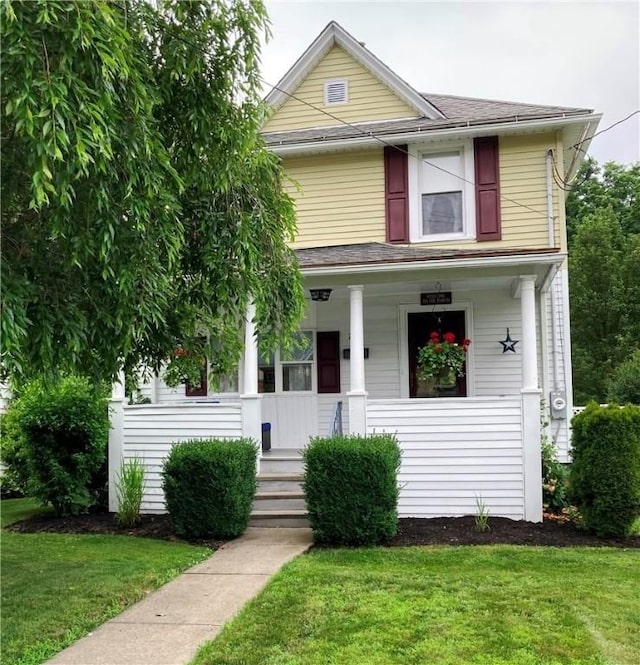 74 Cleveland Ave, Elmira, NY 14905 - american foursquare style home with covered porch, a front lawn, and a shingled roof