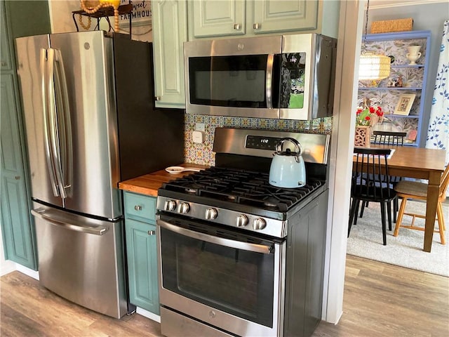 74 Cleveland Ave, Elmira, NY 14905 - kitchen with stainless steel appliances, green cabinetry, light wood finished floors, and backsplash