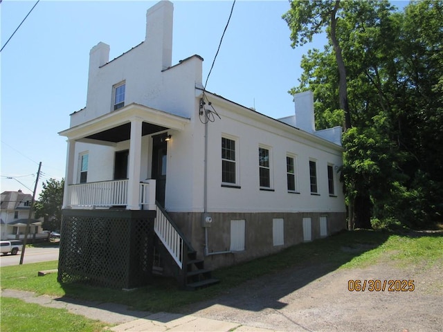 4 Geneva St, Lyons, NY 14489 - view of home's exterior with stairs, a chimney, a porch, and stucco siding