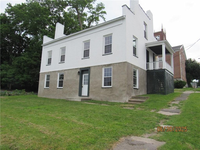 4 Geneva St, Lyons, NY 14489 - view of front of home featuring a chimney, a front lawn, and stucco siding