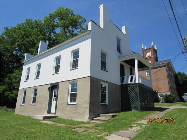 4 Geneva St, Lyons, NY 14489 - view of front of property with a front yard, a chimney, and stucco siding