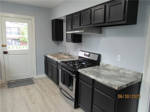 4 Geneva St, Lyons, NY 14489 - kitchen featuring stainless steel range with gas cooktop, under cabinet range hood, dark cabinetry, light wood-type flooring, and light countertops