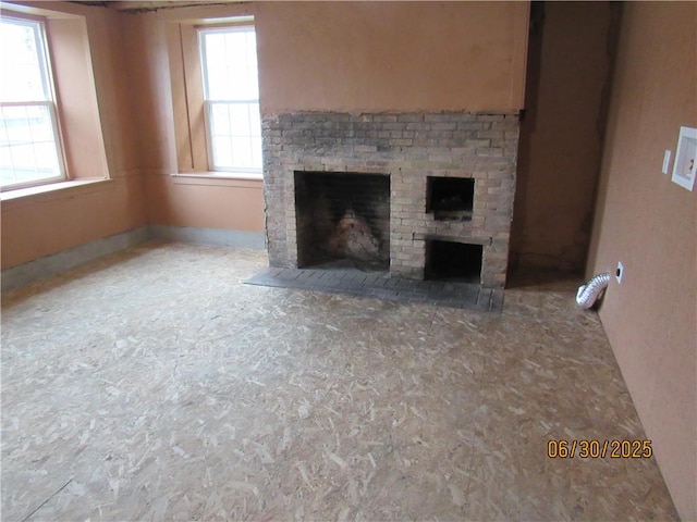 4 Geneva St, Lyons, NY 14489 - unfurnished living room featuring a fireplace and healthy amount of natural light