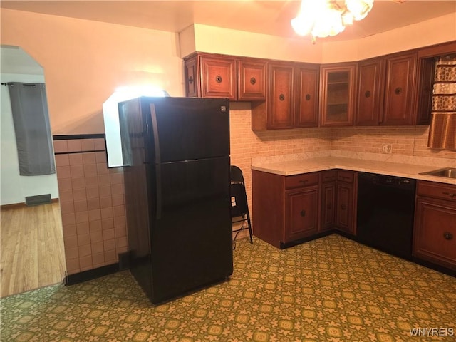 465 18th St, Niagara Falls, NY 14303 - kitchen with black appliances, arched walkways, tile walls, light countertops, and wainscoting