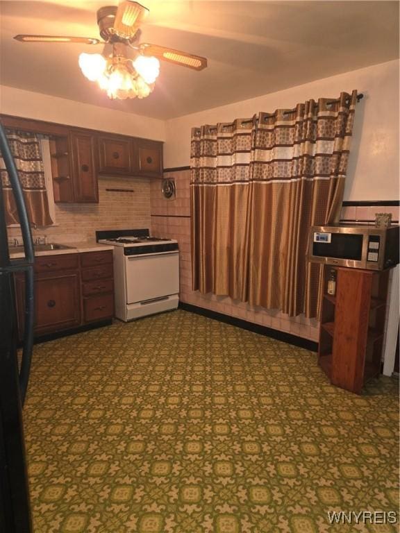 465 18th St, Niagara Falls, NY 14303 - kitchen with gas range gas stove, ceiling fan, stainless steel microwave, open shelves, and freestanding refrigerator