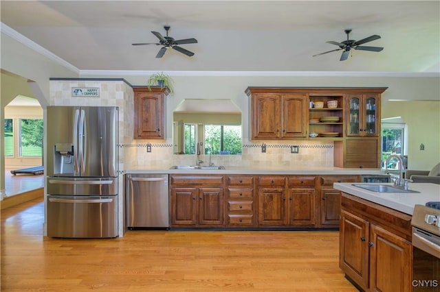 3200 Ransom Rd, Pompey, NY 13078 - kitchen with appliances with stainless steel finishes, a ceiling fan, arched walkways, brown cabinets, and crown molding