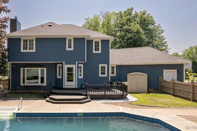 3306 Glen Abbey, Lysander, NY 13135 - rear view of property featuring a wooden deck, an outdoor pool, a storage unit, a chimney, and a shingled roof