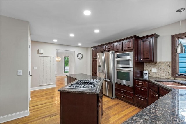 3306 Glen Abbey, Lysander, NY 13135 - kitchen featuring appliances with stainless steel finishes, a center island, light wood-style flooring, decorative backsplash, and recessed lighting