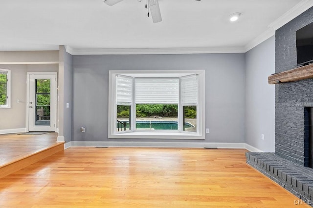3306 Glen Abbey, Lysander, NY 13135 - unfurnished living room featuring a brick fireplace, crown molding, ceiling fan, and wood finished floors