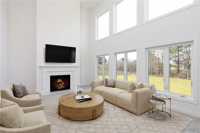 71 Woodthrush Trl, Orchard Park, NY 14127 - living area featuring a warm lit fireplace and a high ceiling