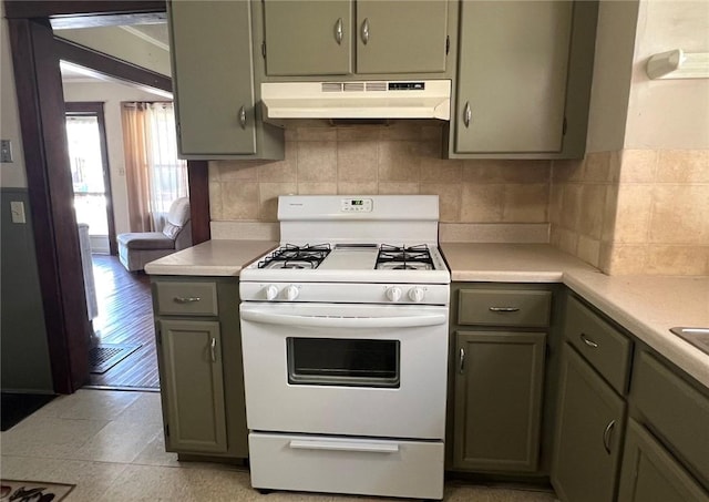 914 Magee St, Elmira City, NY 14901 - kitchen featuring under cabinet range hood, white gas range, light countertops, tasteful backsplash, and gray cabinetry