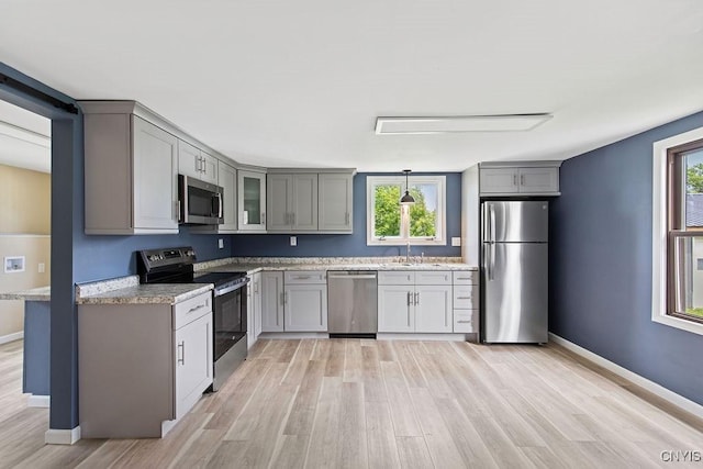 81 E 10th St, Oswego, NY 13126 - kitchen with appliances with stainless steel finishes, gray cabinetry, plenty of natural light, and light wood-style floors