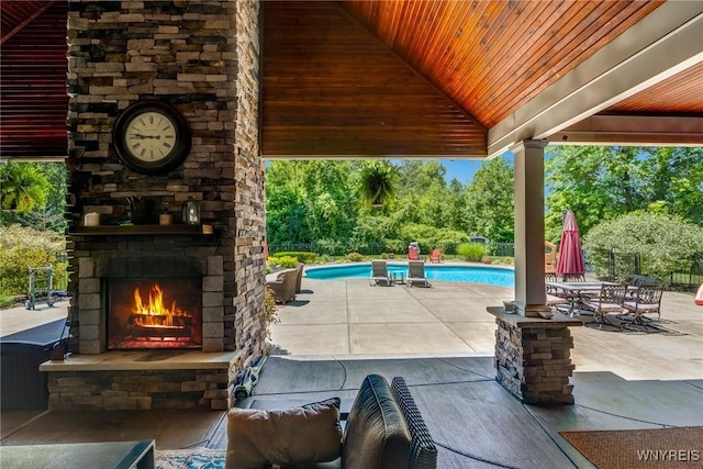 4614 Vrooman Dr, Lewiston, NY 14092 - view of patio featuring an outdoor stone fireplace, an outdoor pool, and view of wooded area