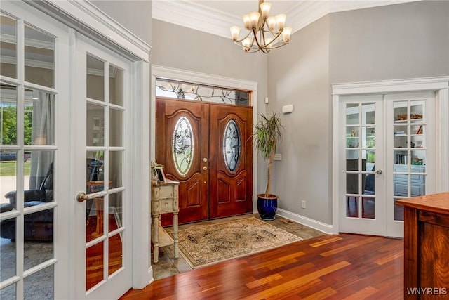 4614 Vrooman Dr, Lewiston, NY 14092 - foyer entrance featuring french doors, a chandelier, wood finished floors, ornamental molding, and healthy amount of natural light