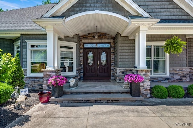 4614 Vrooman Dr, Lewiston, NY 14092 - doorway to property with stone siding, a shingled roof, and a porch