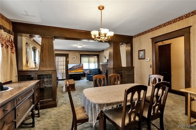 53 Pine Rdg, Cheektowaga, NY 14225 - dining space with light colored carpet, a chandelier, wallpapered walls, and crown molding