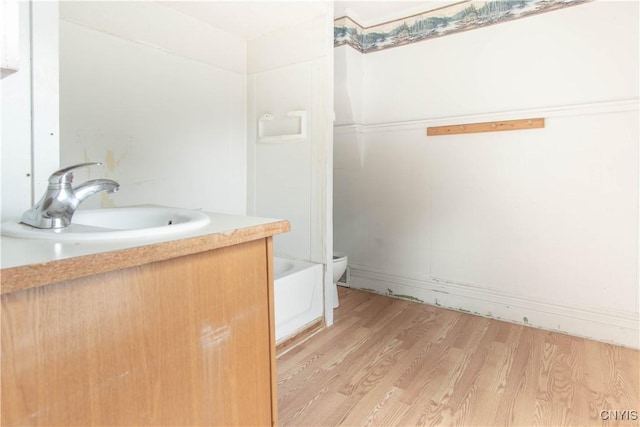 662 Burchard St, Watertown City, NY 13601 - bathroom featuring wood finished floors, vanity, and a tub to relax in