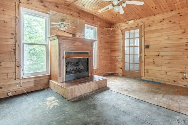 662 Burchard St, Watertown City, NY 13601 - unfurnished living room featuring a ceiling fan, wood walls, wood ceiling, a fireplace with raised hearth, and lofted ceiling