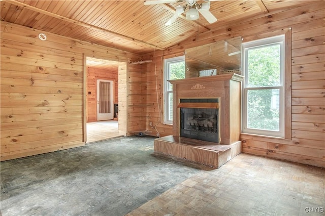 662 Burchard St, Watertown City, NY 13601 - unfurnished living room with wooden walls, healthy amount of natural light, a ceiling fan, vaulted ceiling, and a fireplace with raised hearth