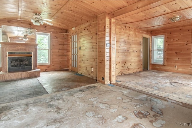 662 Burchard St, Watertown City, NY 13601 - unfurnished living room featuring healthy amount of natural light, ceiling fan, a fireplace with raised hearth, wooden ceiling, and wooden walls