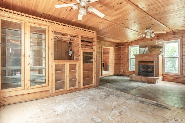 662 Burchard St, Watertown City, NY 13601 - unfurnished living room with a ceiling fan, healthy amount of natural light, a fireplace with raised hearth, and wooden walls