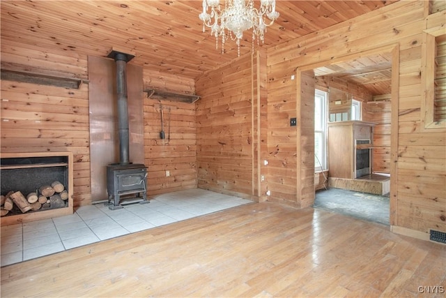 662 Burchard St, Watertown City, NY 13601 - unfurnished living room with a fireplace, wood ceiling, wood-type flooring, wooden walls, and a wood stove