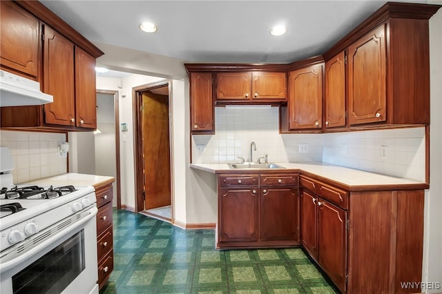 74 Bush St, Buffalo, NY 14207 - kitchen featuring gas range gas stove, under cabinet range hood, light countertops, dark flooring, and decorative backsplash