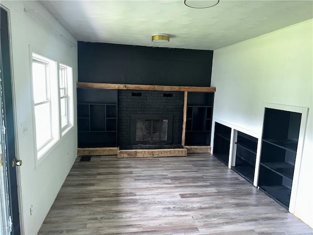 8557 Reeds Corners Rd, Sparta, NY 14437 - unfurnished living room featuring wood finished floors and a brick fireplace