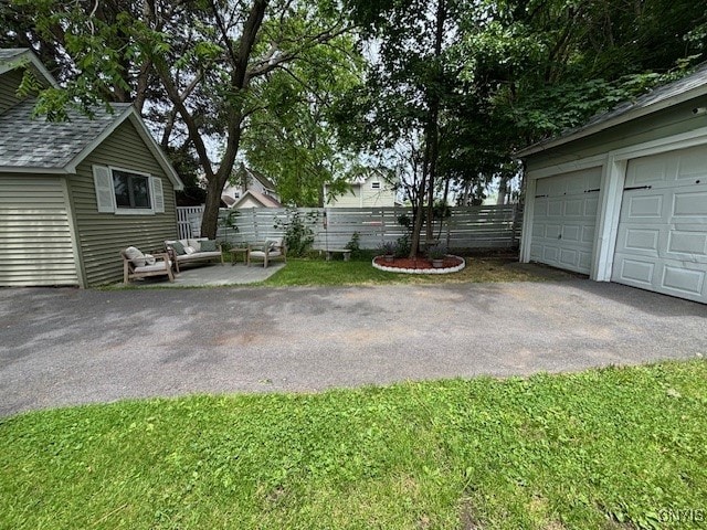 1 Mcbride St, Kirkland, NY 13323 - view of yard featuring a garage, an outdoor hangout area, and asphalt driveway