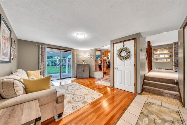 17 Treehaven Rd, West Seneca, NY 14224 - living area with stairs, a textured ceiling, and light wood-type flooring