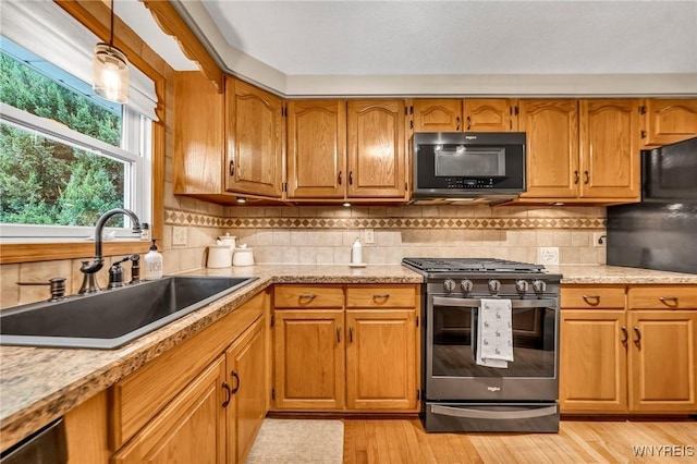17 Treehaven Rd, West Seneca, NY 14224 - kitchen with black microwave, stainless steel gas range oven, brown cabinets, and tasteful backsplash
