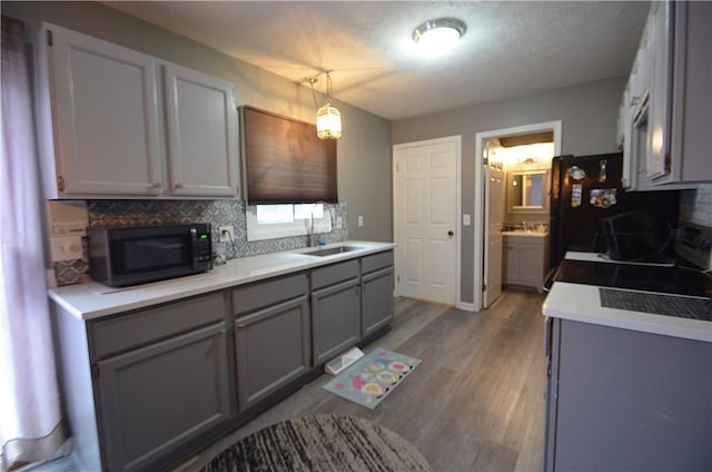 122 Thorn Apple Ln, Greece, NY 14626 - kitchen with gray cabinets, black microwave, backsplash, wood finished floors, and range