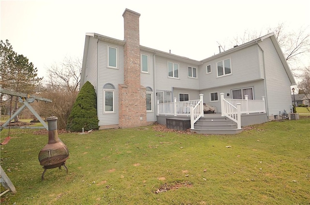 122 Thorn Apple Ln, Greece, NY 14626 - rear view of house featuring an outdoor fire pit, a chimney, a wooden deck, and a lawn