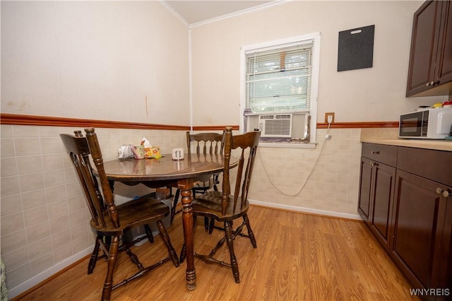 13 Highland Pl, Lancaster, NY 14086 - dining space with tile walls, crown molding, cooling unit, light wood-style floors, and wainscoting