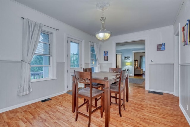 2360 Harris Rd, Palmyra, NY 14522 - dining space featuring light wood-style flooring, crown molding, a wainscoted wall, and a decorative wall